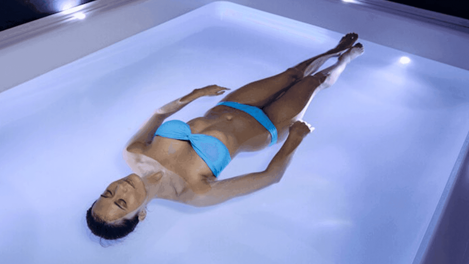 Woman relaxing and floating in the pool of hotel Float